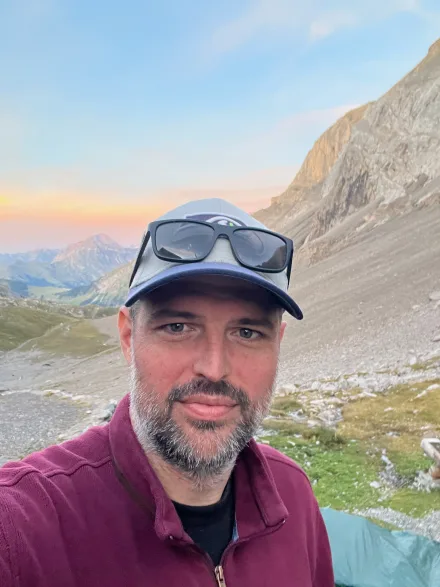 Marco Burger in den Bergen, im Hintergrund ein Bergkessel im Morgenlicht